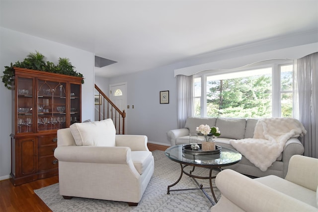 living area with stairway, a wealth of natural light, wood finished floors, and baseboards