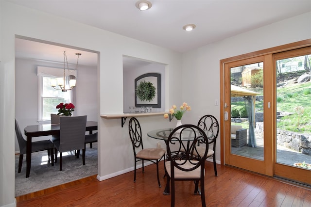 dining area featuring an inviting chandelier, wood finished floors, and baseboards