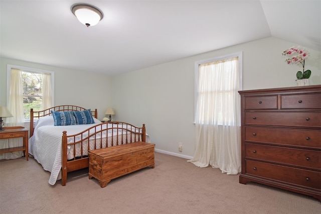 bedroom with vaulted ceiling and light carpet