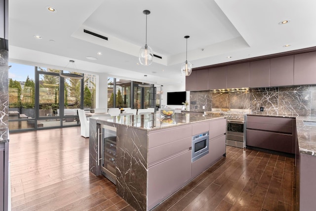 kitchen featuring dark wood finished floors, decorative backsplash, a raised ceiling, and modern cabinets