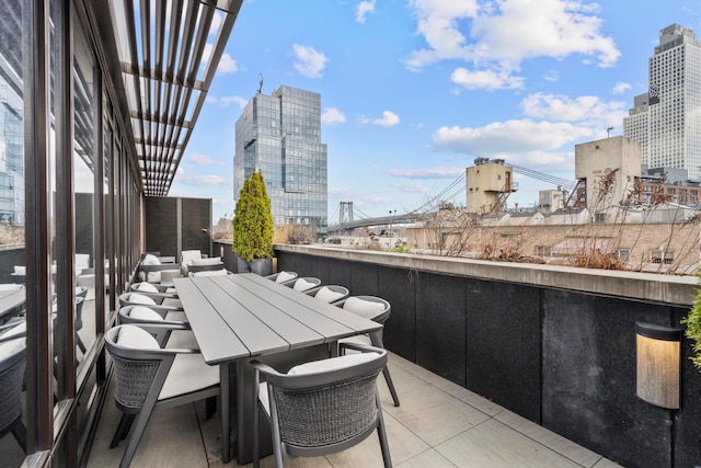 balcony featuring outdoor dining space and a city view