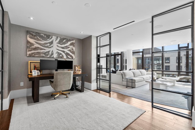 office area with baseboards, wood finished floors, and floor to ceiling windows