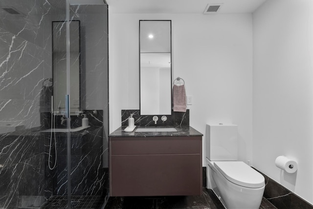 bathroom featuring visible vents, toilet, vanity, a marble finish shower, and marble finish floor