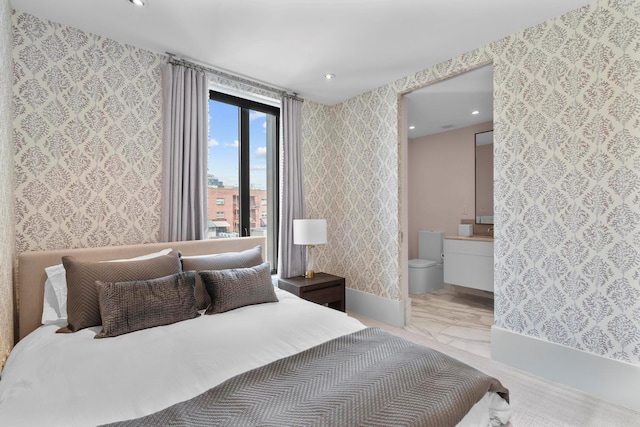 bedroom featuring recessed lighting, ensuite bathroom, and wallpapered walls