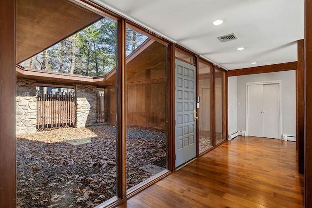 interior space featuring visible vents, recessed lighting, a baseboard heating unit, a baseboard radiator, and wood-type flooring