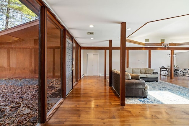 corridor featuring visible vents, a baseboard radiator, recessed lighting, and wood finished floors