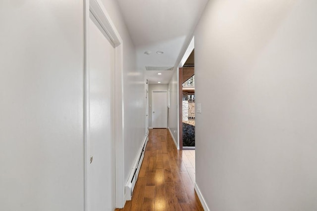 hallway with recessed lighting, hardwood / wood-style flooring, a baseboard radiator, and baseboards