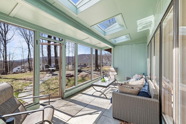 sunroom with a mountain view and a skylight