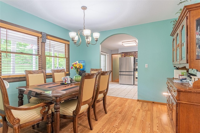 6 Swain Dr, Pleasant Valley, NY 12569 - dining room featuring arched walkways, a chandelier, light wood-style flooring, and baseboards