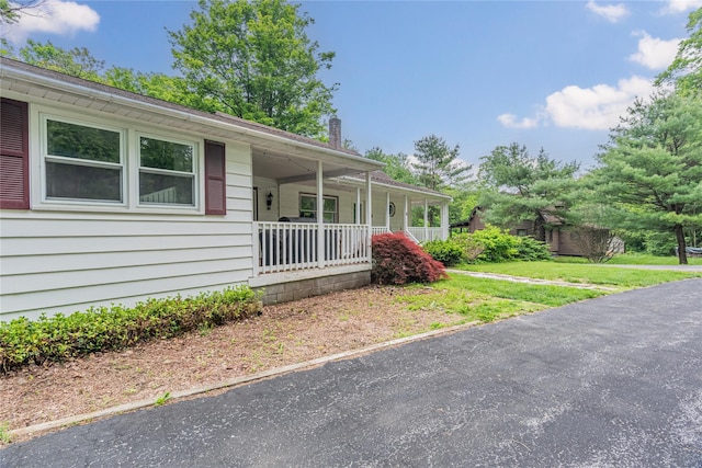 6 Swain Dr, Pleasant Valley, NY 12569 - view of front facade with covered porch, a chimney, and a front lawn