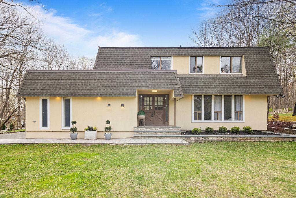 3 Footstep Ln, Pomona, NY 10970 - view of front property featuring mansard roof, a front yard, and stucco siding