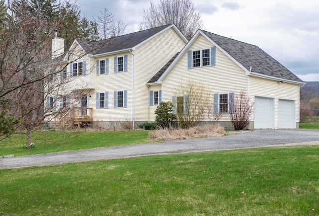 view of front of property featuring aphalt driveway, a front yard, roof with shingles, a chimney, and an attached garage