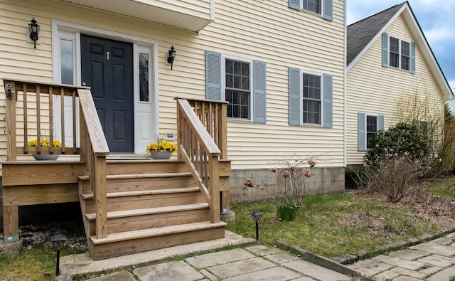 view of exterior entry featuring roof with shingles
