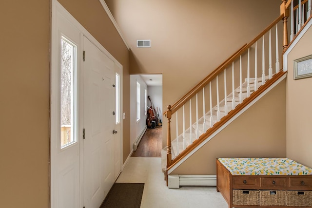entrance foyer featuring a wealth of natural light, baseboard heating, stairs, and visible vents