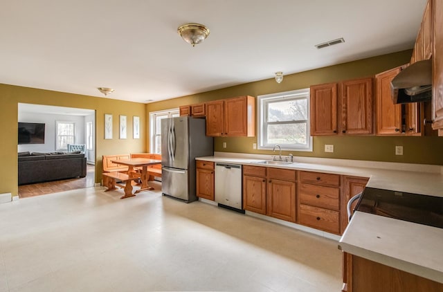 kitchen featuring visible vents, appliances with stainless steel finishes, a sink, light countertops, and under cabinet range hood