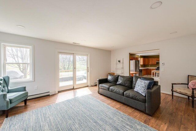 living room with recessed lighting, visible vents, wood finished floors, and a baseboard radiator