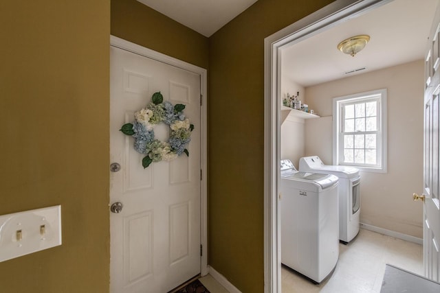 washroom with baseboards, visible vents, laundry area, and washer and clothes dryer