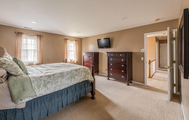 bedroom featuring light colored carpet, baseboards, and visible vents
