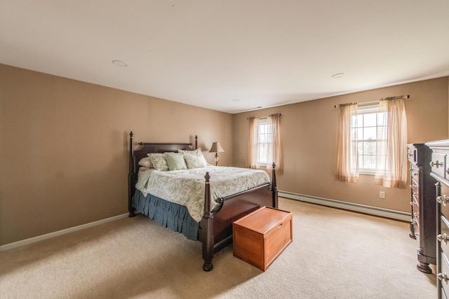 bedroom with light colored carpet, baseboards, and a baseboard heating unit