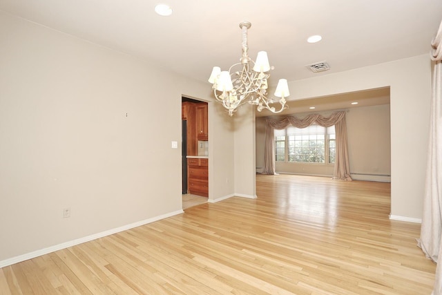 empty room featuring visible vents, baseboards, a baseboard radiator, a chandelier, and light wood-style floors