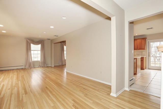 interior space with recessed lighting, a healthy amount of sunlight, light wood finished floors, and a baseboard radiator