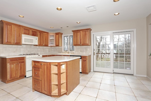 kitchen with white appliances, backsplash, light tile patterned flooring, and light countertops