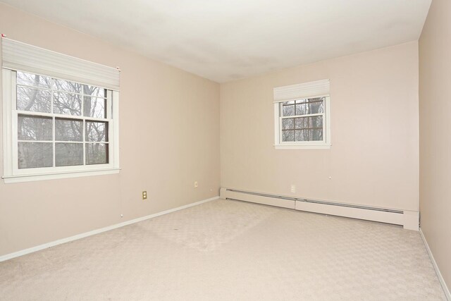 carpeted spare room featuring baseboards and baseboard heating