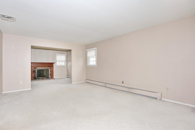 unfurnished living room with visible vents, a fireplace, baseboards, light colored carpet, and a baseboard radiator
