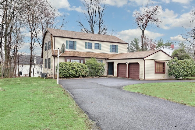 traditional-style house with a garage, central air condition unit, driveway, and a front yard