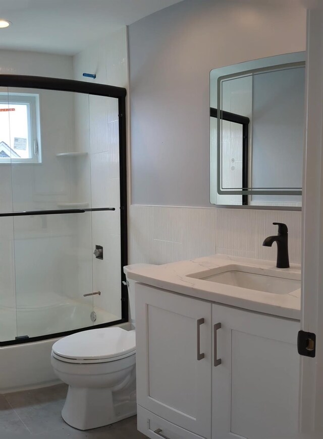 1135 Logan Rd, Wantagh, NY 11793 - bathroom featuring vanity, shower / bath combination with glass door, and a wainscoted wall