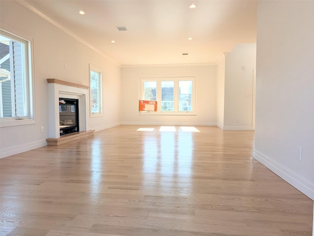 1135 Logan Rd, Wantagh, NY 11793 - unfurnished living room with light wood-style floors, baseboards, crown molding, recessed lighting, and a glass covered fireplace