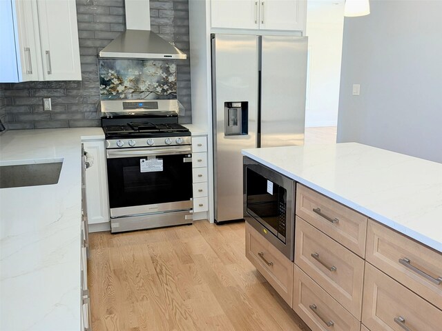 1135 Logan Rd, Wantagh, NY 11793 - kitchen with stainless steel appliances, extractor fan, light wood finished floors, decorative backsplash, and light stone counters