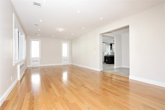 unfurnished room featuring visible vents, baseboards, light wood-type flooring, and recessed lighting