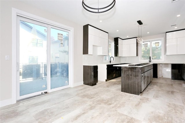 kitchen with pendant lighting, white cabinets, a center island, and modern cabinets