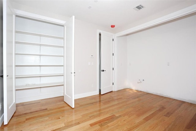 unfurnished bedroom with visible vents and light wood-style flooring
