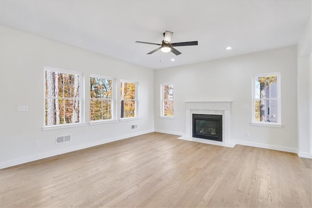 unfurnished living room with visible vents, ceiling fan, and a healthy amount of sunlight