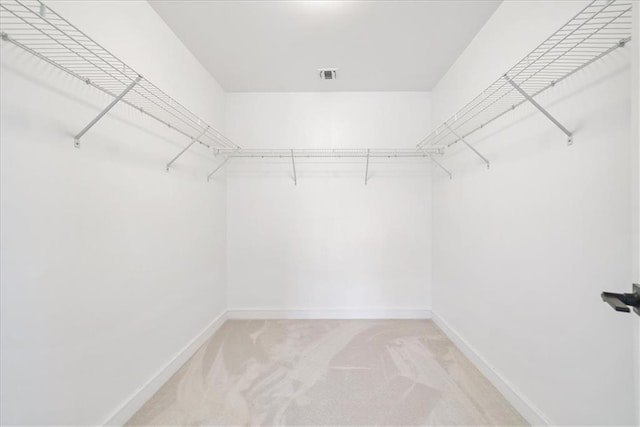 spacious closet featuring visible vents and light colored carpet