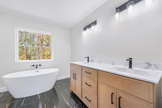 bathroom with a soaking tub, double vanity, a sink, and baseboards