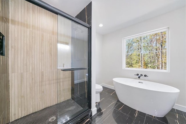 bathroom featuring baseboards, toilet, a soaking tub, a shower stall, and recessed lighting