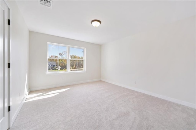 empty room with baseboards, visible vents, and carpet floors