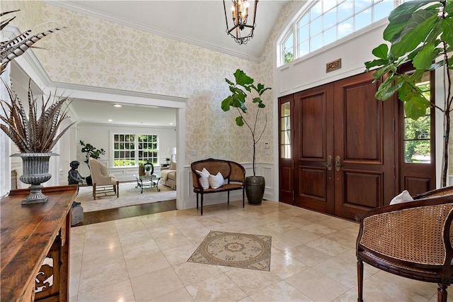 70 Haights Cross Rd, Chappaqua, NY 10514 - foyer with lofted ceiling, wallpapered walls, a chandelier, wainscoting, and ornamental molding