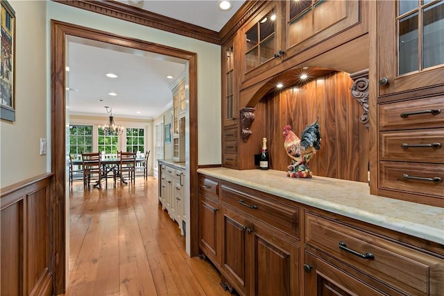 70 Haights Cross Rd, Chappaqua, NY 10514 - kitchen featuring ornamental molding, a chandelier, wainscoting, light wood-style floors, and brown cabinetry