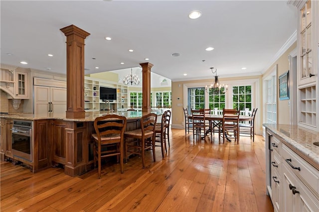 70 Haights Cross Rd, Chappaqua, NY 10514 - kitchen with ornate columns, oven, a chandelier, glass insert cabinets, and crown molding