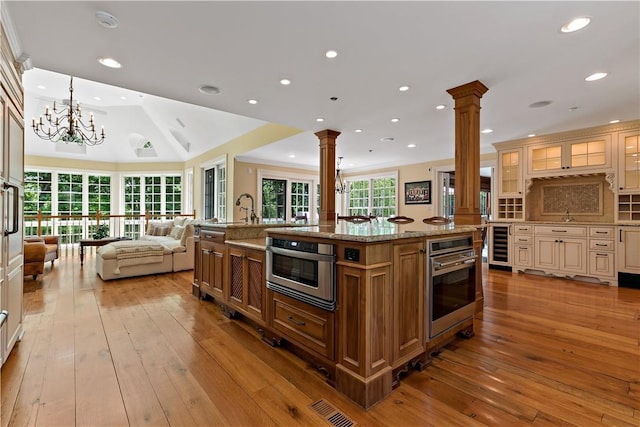 70 Haights Cross Rd, Chappaqua, NY 10514 - kitchen with oven, decorative columns, wine cooler, open floor plan, and cream cabinetry