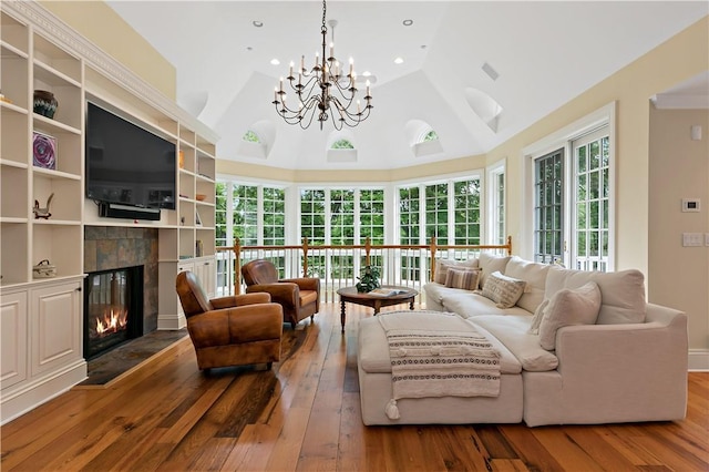 70 Haights Cross Rd, Chappaqua, NY 10514 - living room featuring hardwood / wood-style floors, a chandelier, a tile fireplace, high vaulted ceiling, and built in features
