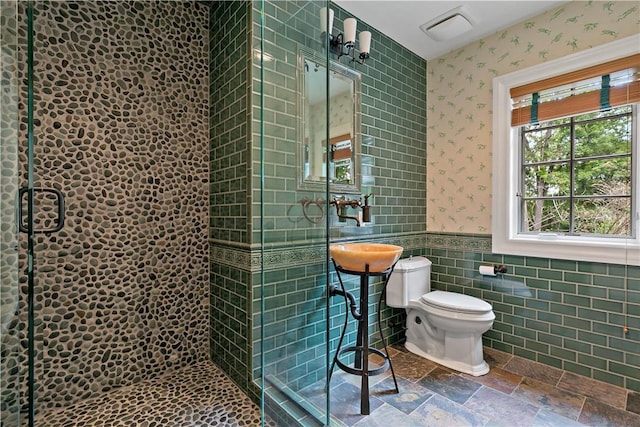 70 Haights Cross Rd, Chappaqua, NY 10514 - full bath featuring wallpapered walls, toilet, a wainscoted wall, stone finish flooring, and a tile shower