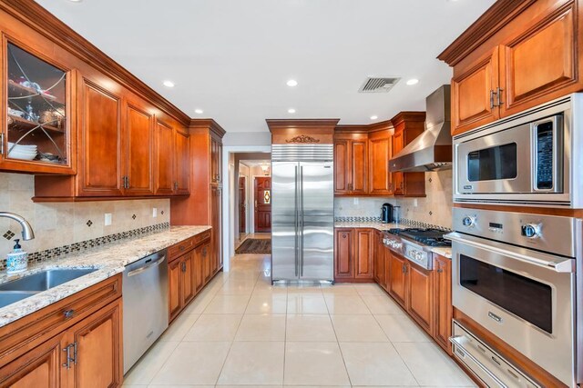 34 Duke Dr, Manhasset Hills, NY 11040 - kitchen featuring wall chimney exhaust hood, a warming drawer, visible vents, built in appliances, and light stone counters