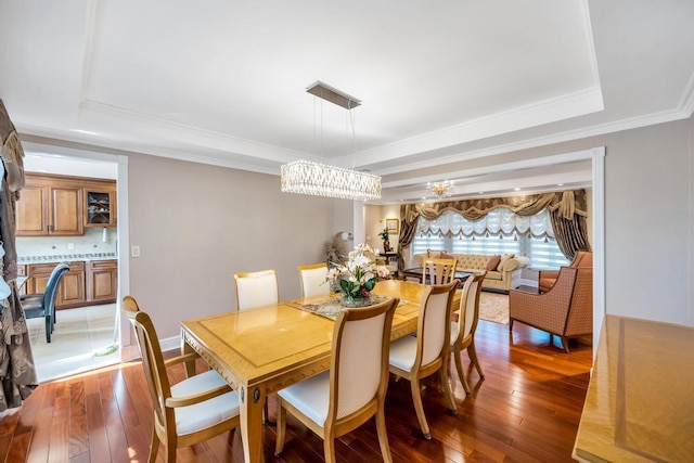 34 Duke Dr, Manhasset Hills, NY 11040 - dining space with hardwood / wood-style floors, a tray ceiling, an inviting chandelier, and ornamental molding