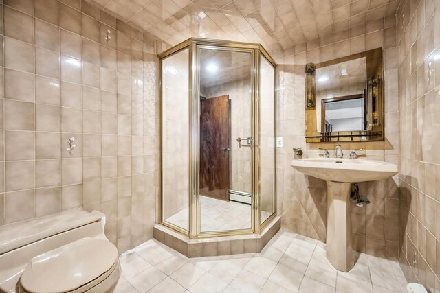 34 Duke Dr, Manhasset Hills, NY 11040 - bathroom with baseboard heating, tile patterned floors, and tile walls