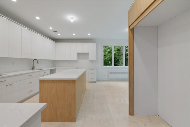 5 Francis Pl Unit 214, Monsey, NY 10952 - kitchen featuring radiator, modern cabinets, recessed lighting, white cabinetry, and a kitchen island